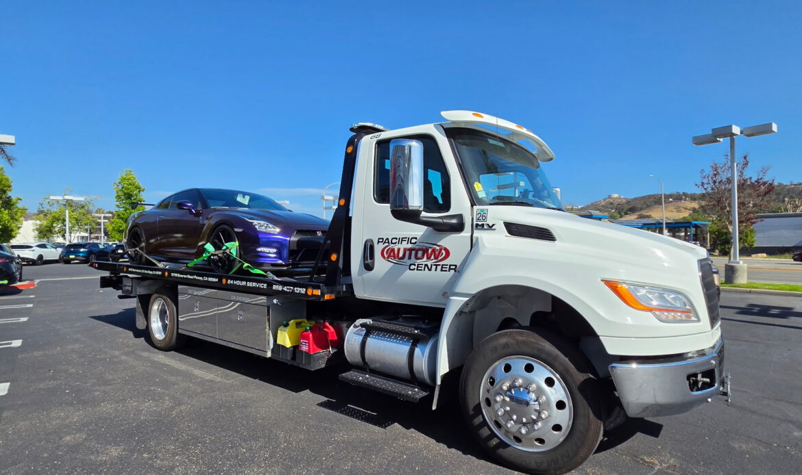 Pacific Autow Center flatbed truck carrying a sports car