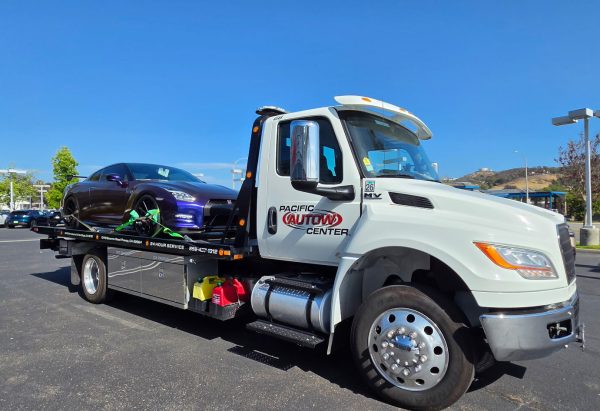 Pacific Autow Center flatbed truck carrying a sports car